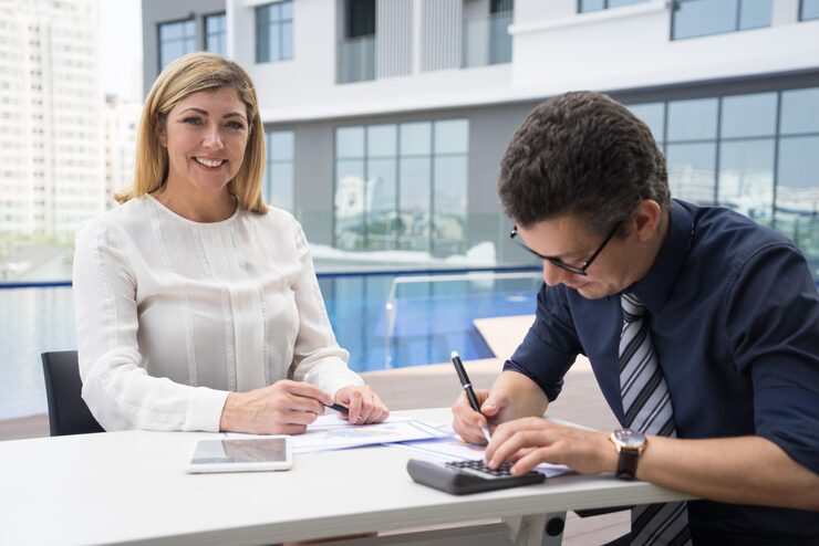 cheerful-excited-mature-female-financier-smiling-while-accountant-using-calculator
