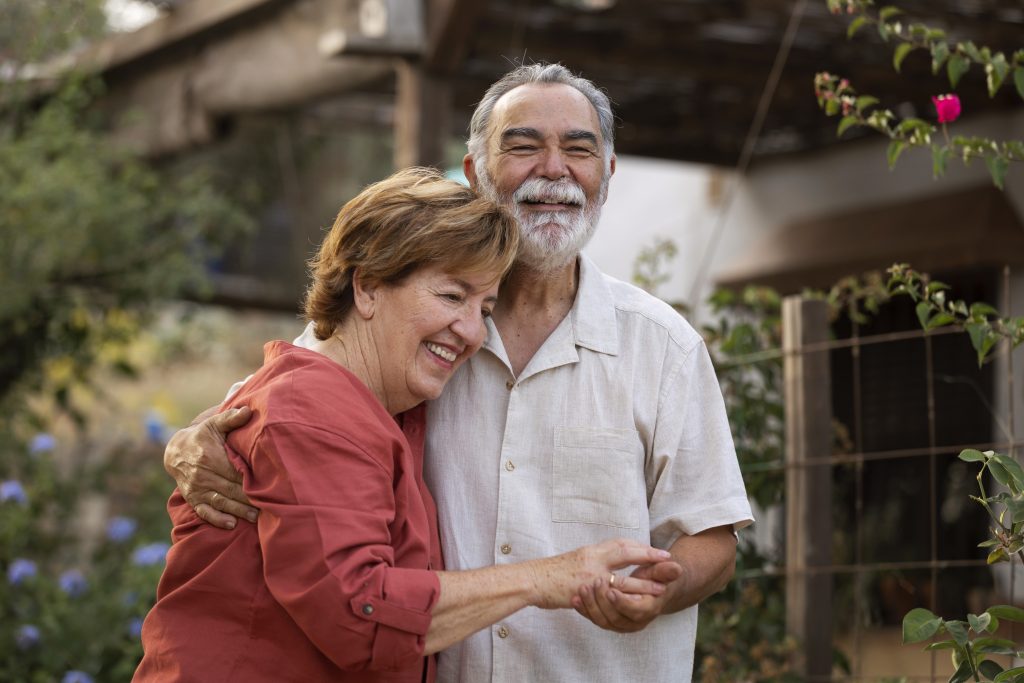 elderly-couple-holding-each-other-romantically-their-countryside-home-garden