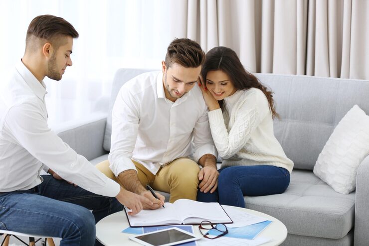 estate-agent-meeting-with-happy-couple