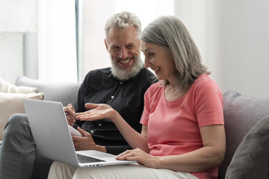 older-couple-home-couch-using-laptop
