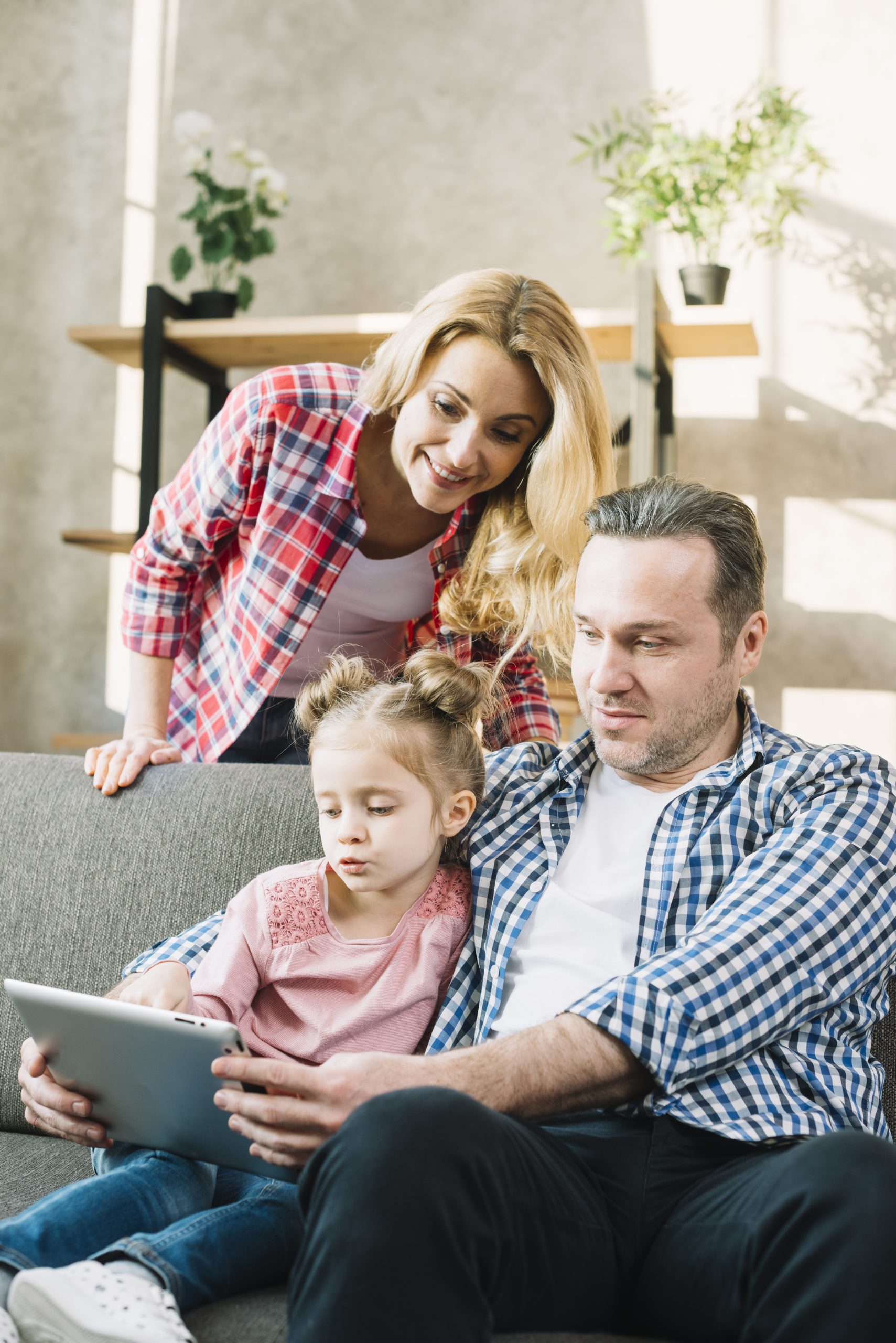 smiling-family-using-digital-tablet-together-home