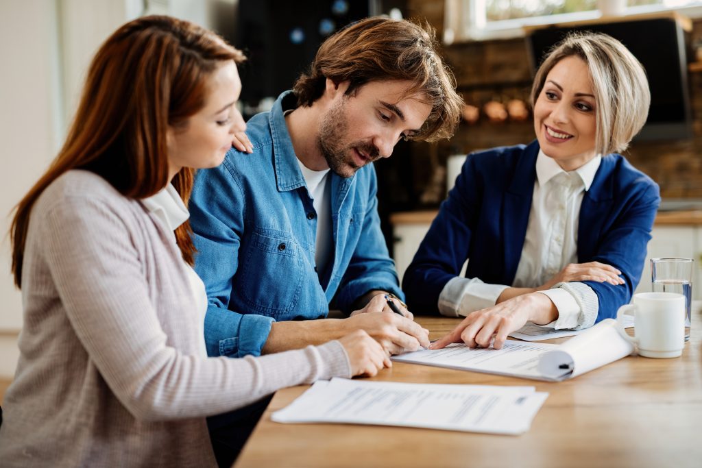 Young couple signing a contract on a meeting with financial advi